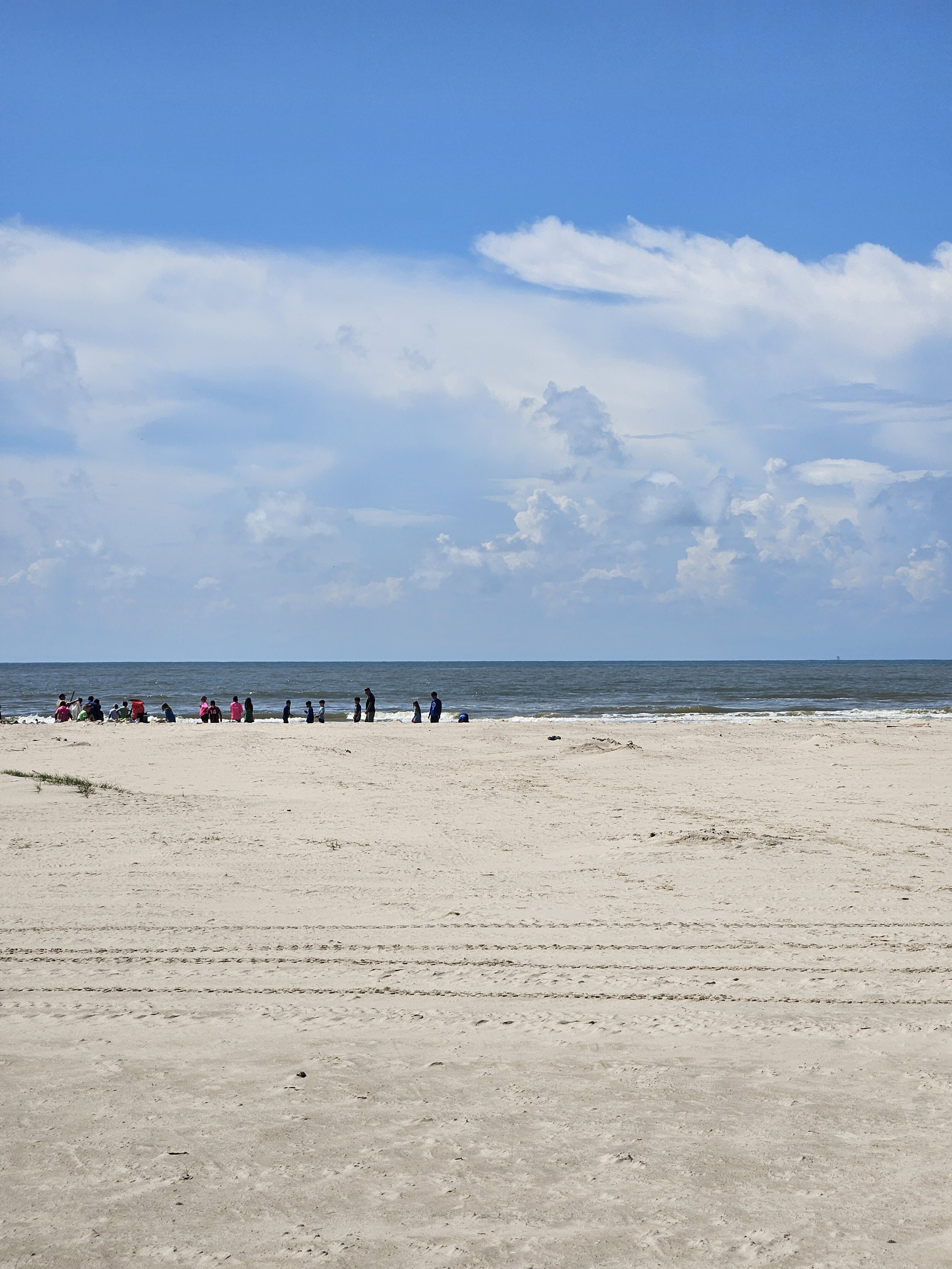 Runners and families on the wide beach at Matagorda